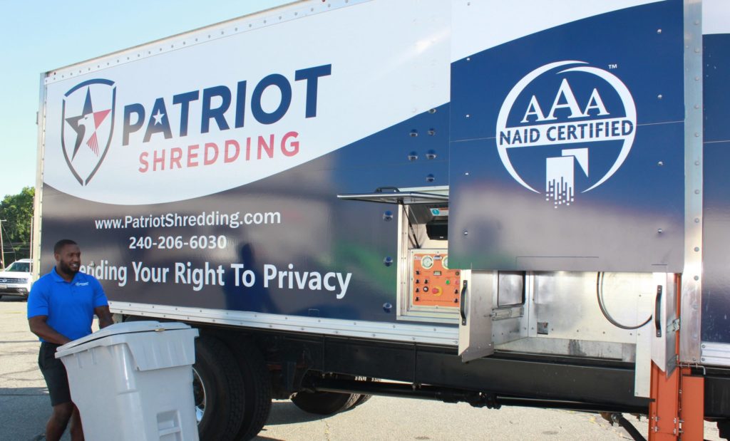 patriot shredding employee wheeling paper to truck